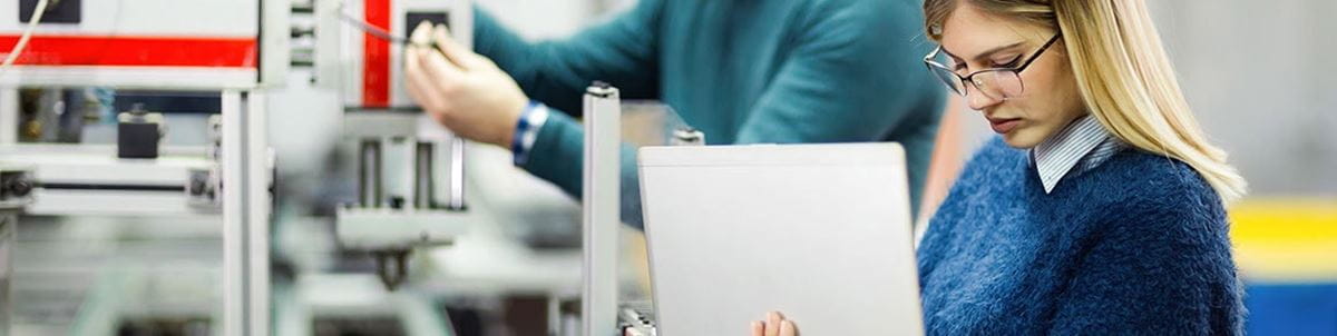 Photo of a manufacturing facility person working on a laptop