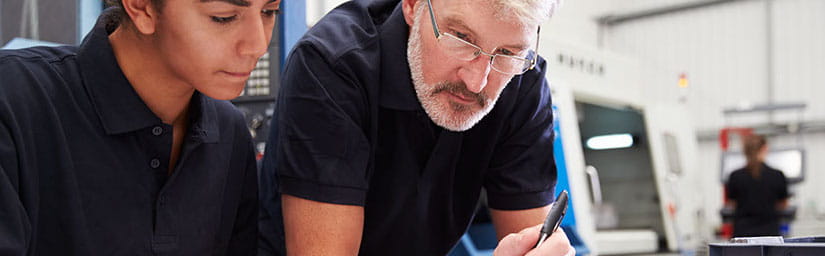 Photo of 2 people reviewing documents on a desk