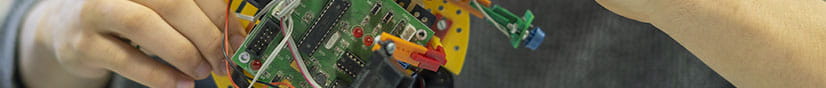 Photo od a circuit board with hands working on it